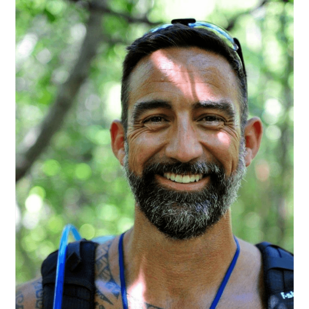 Kevin Ramirez, co-founder of IMPOWER Life, smiling on a forest trail